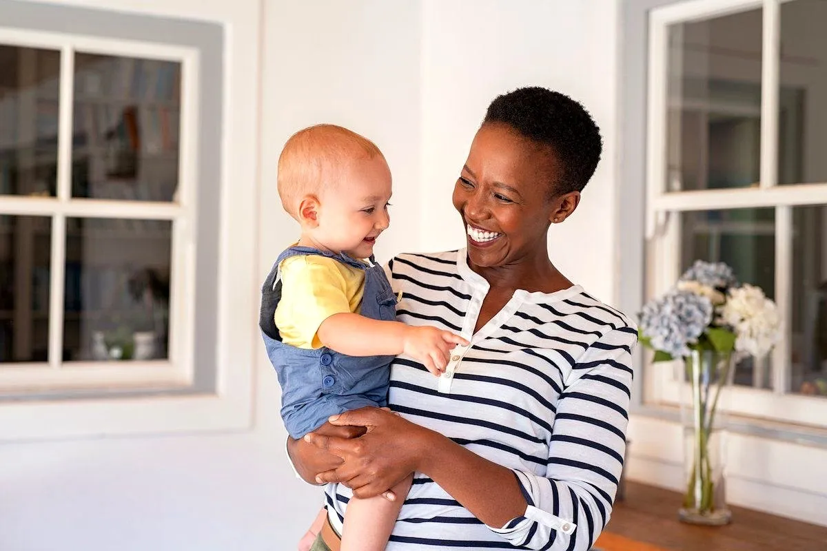 A Kenyan nanny caring for a young child at home